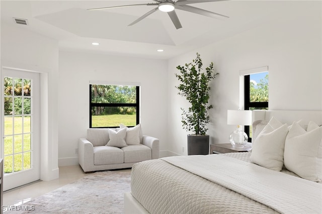 tiled bedroom featuring ceiling fan and multiple windows