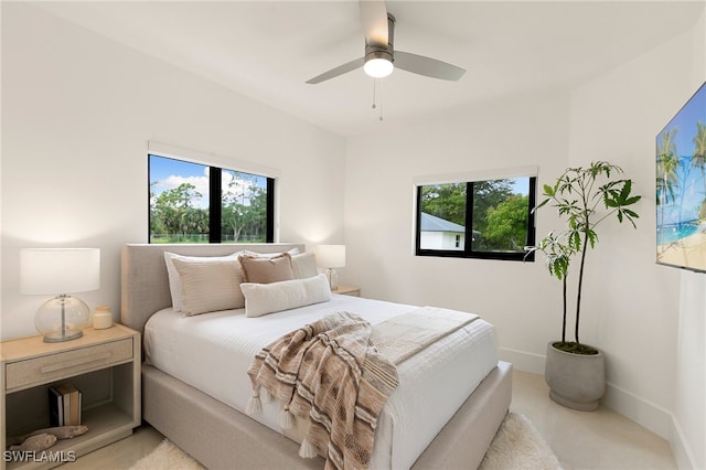 bedroom with multiple windows, ceiling fan, and light colored carpet