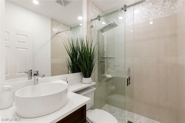 bathroom featuring vanity, toilet, and a shower with door