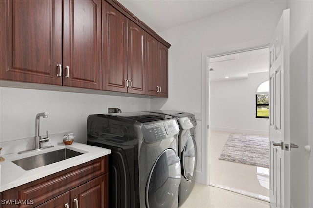 laundry area with cabinets, light tile patterned floors, separate washer and dryer, and sink