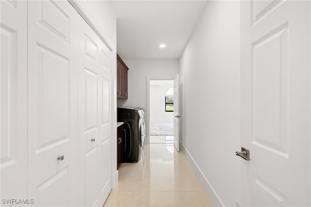 hall featuring light tile patterned flooring and washer and dryer