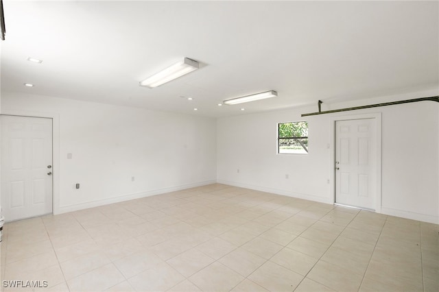 empty room featuring light tile patterned flooring and a barn door