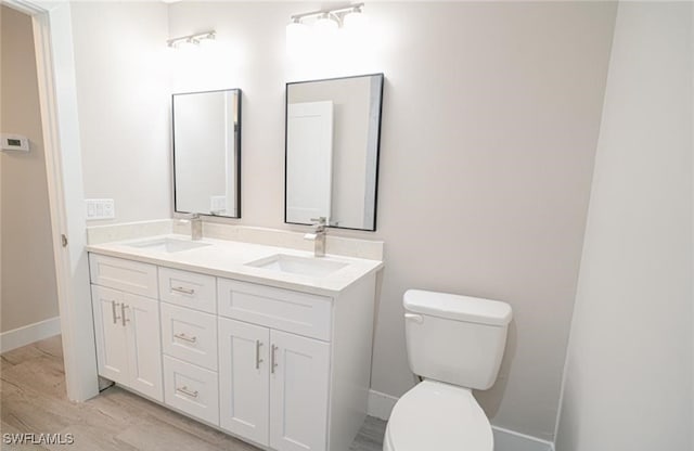 bathroom with hardwood / wood-style floors, toilet, and vanity