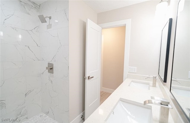 bathroom with vanity, hardwood / wood-style flooring, and tiled shower