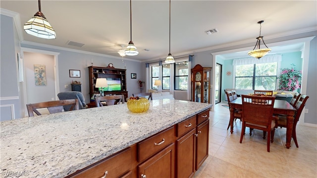 kitchen with hanging light fixtures, light stone countertops, and plenty of natural light