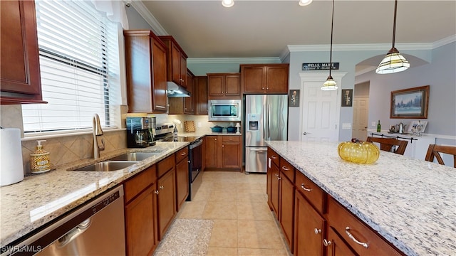 kitchen with sink, a kitchen bar, hanging light fixtures, light stone counters, and stainless steel appliances