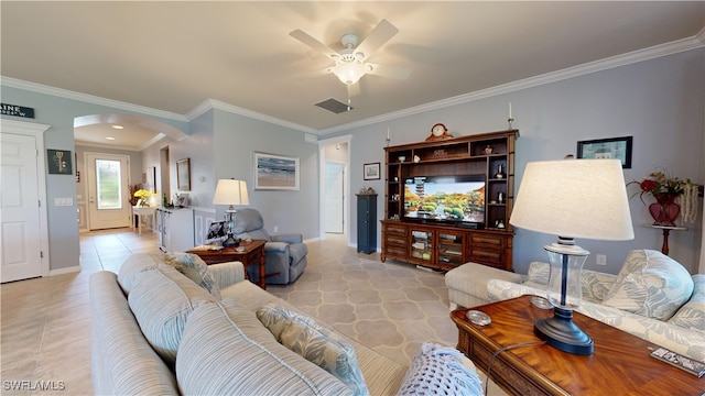 living area featuring baseboards, ornamental molding, light tile patterned flooring, arched walkways, and a ceiling fan