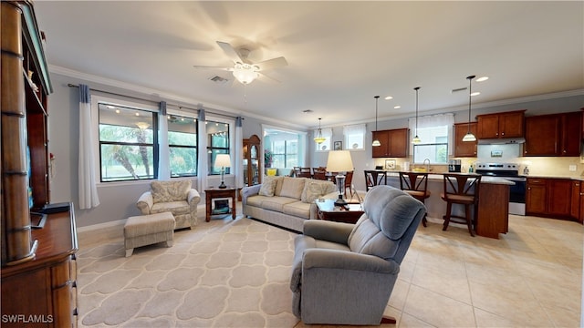 tiled living room featuring plenty of natural light, ornamental molding, and ceiling fan