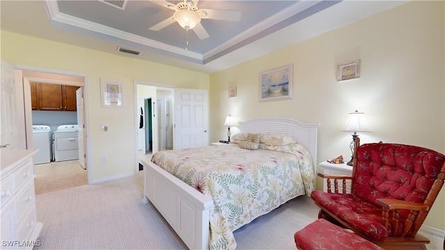 bedroom featuring a raised ceiling, separate washer and dryer, baseboards, and visible vents