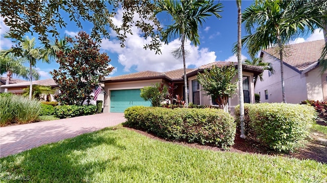 view of front facade with a front yard, decorative driveway, an attached garage, and stucco siding