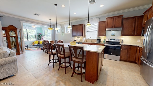 kitchen featuring visible vents, ornamental molding, under cabinet range hood, a sink, and appliances with stainless steel finishes