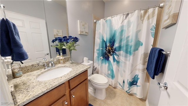 bathroom with tile patterned flooring, vanity, and toilet