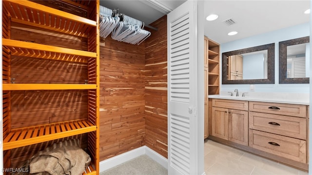 spacious closet with sink and light tile patterned floors