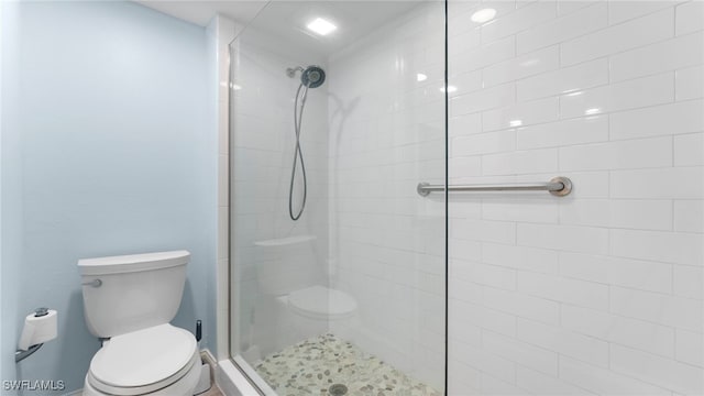 bathroom with toilet and a shower with door