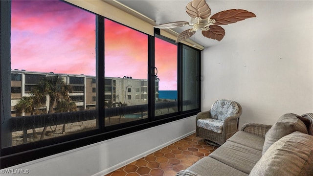 tiled living room with a water view and ceiling fan