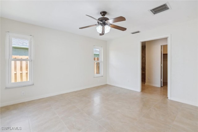 empty room with visible vents, baseboards, and ceiling fan