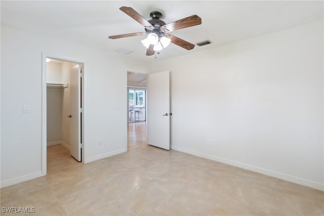 unfurnished bedroom featuring ceiling fan, a walk in closet, and a closet