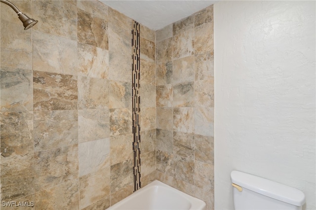 bathroom featuring tiled shower / bath and toilet