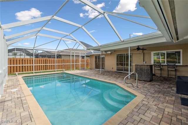 view of swimming pool with glass enclosure, a patio, fence, a fenced in pool, and outdoor dry bar