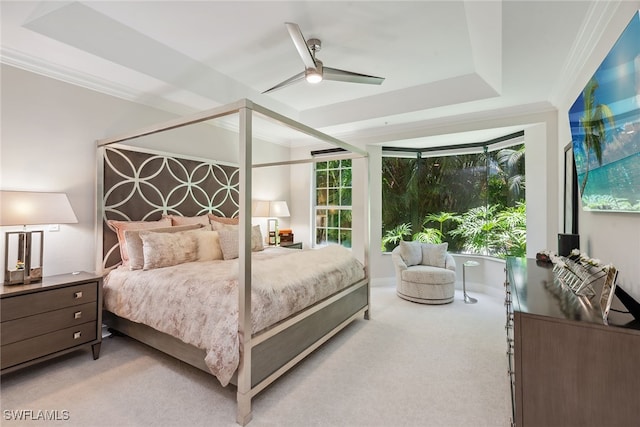 carpeted bedroom with crown molding, ceiling fan, and a tray ceiling