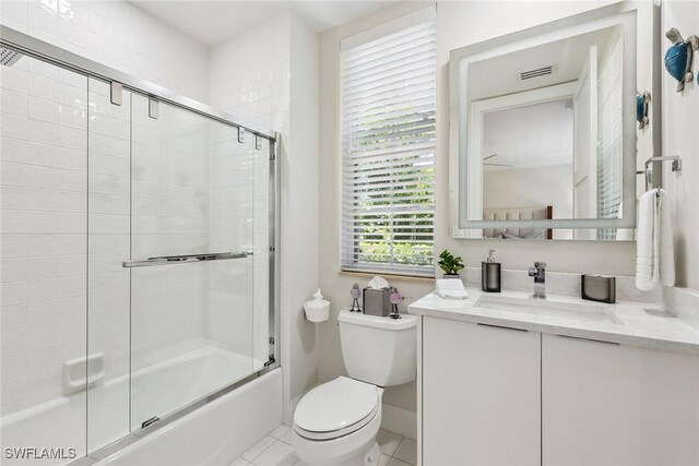 full bathroom with vanity, toilet, tile patterned flooring, and bath / shower combo with glass door