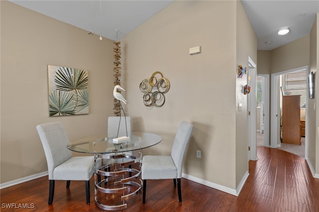 dining space with a high ceiling and dark hardwood / wood-style floors