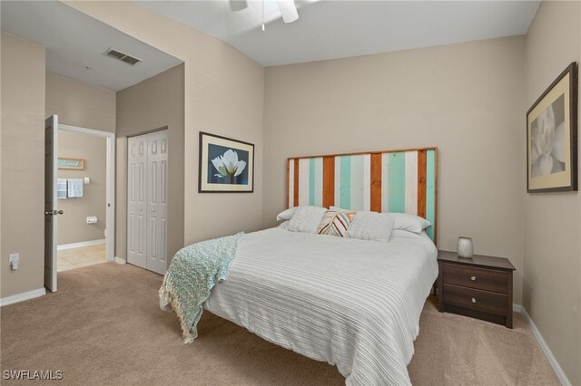 carpeted bedroom featuring lofted ceiling, ceiling fan, and a closet