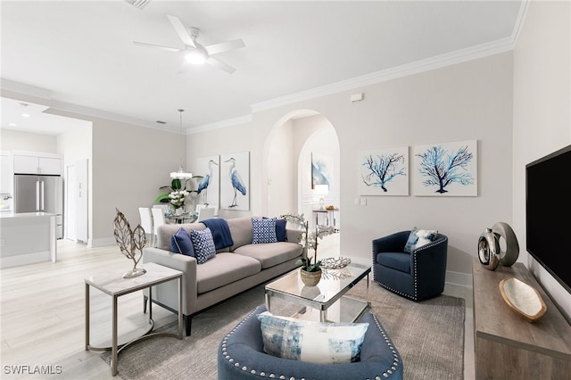 living room with light hardwood / wood-style floors, crown molding, and ceiling fan