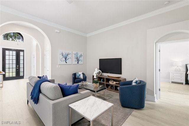 living room featuring crown molding, light hardwood / wood-style flooring, and french doors