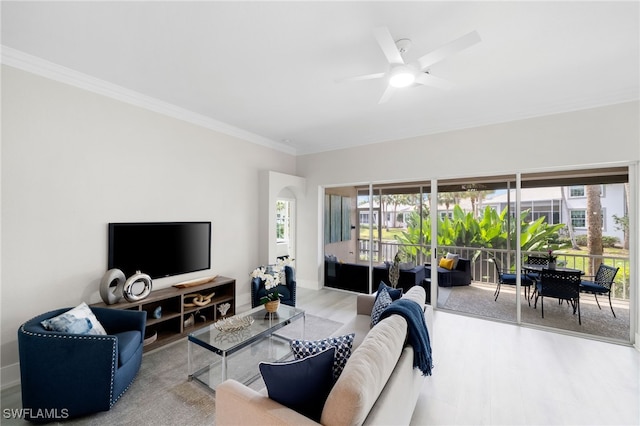 living room with ceiling fan, crown molding, and light wood-type flooring