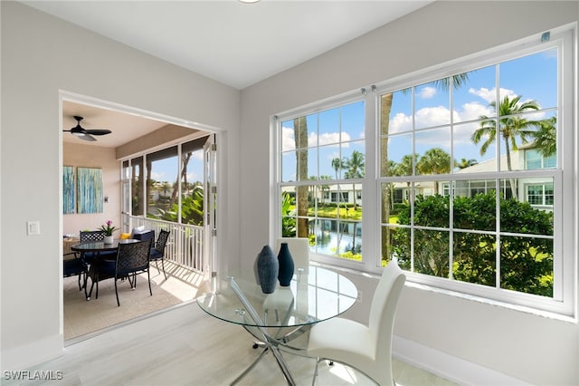 sunroom with a water view, ceiling fan, and plenty of natural light