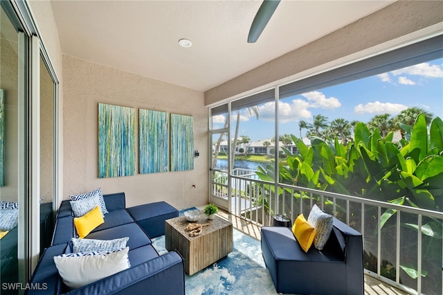 sunroom / solarium featuring a water view and ceiling fan