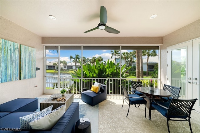 sunroom / solarium featuring french doors, a water view, and ceiling fan