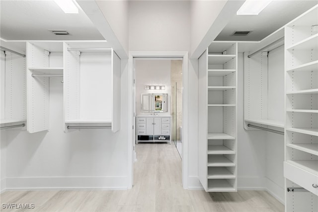 walk in closet with light wood-type flooring