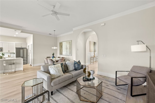 living room featuring crown molding, light hardwood / wood-style flooring, and ceiling fan