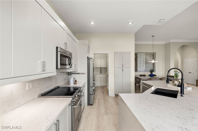 kitchen featuring pendant lighting, sink, white cabinetry, and appliances with stainless steel finishes