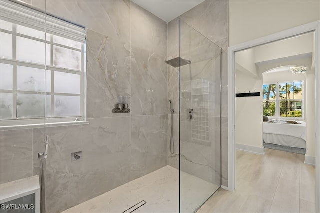 bathroom featuring wood-type flooring and a tile shower