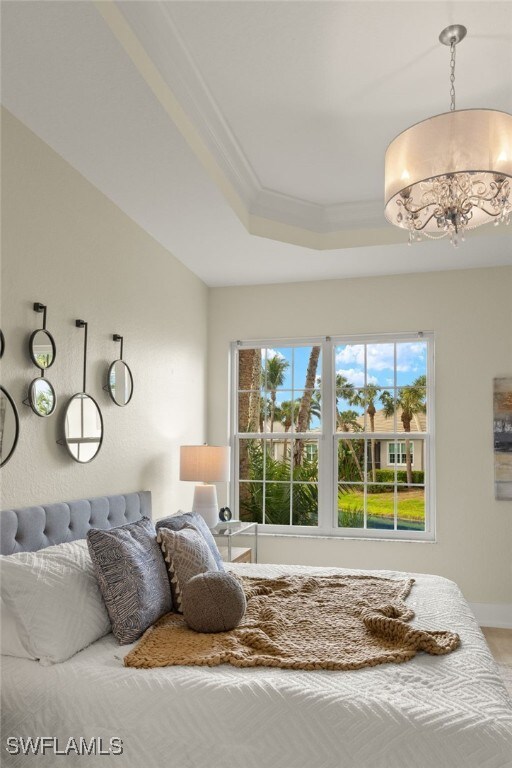 bedroom featuring crown molding, a chandelier, and a tray ceiling