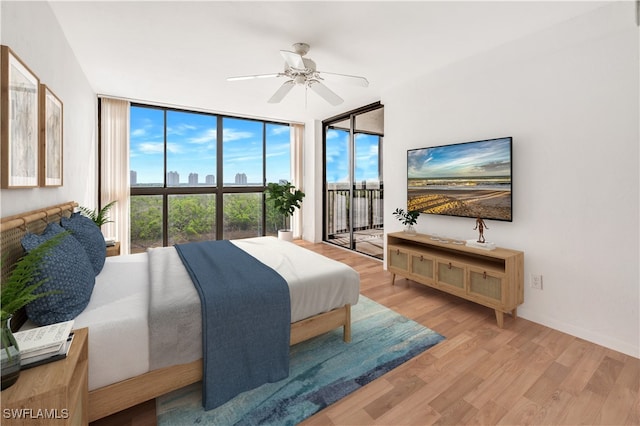 bedroom with multiple windows, wood-type flooring, and ceiling fan