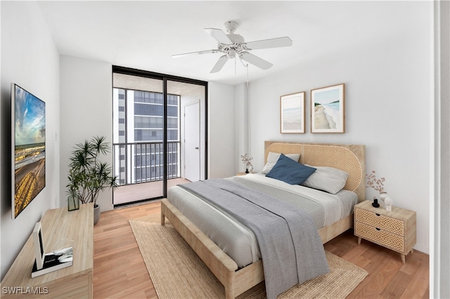 bedroom featuring light wood-type flooring, a wall of windows, ceiling fan, and access to exterior