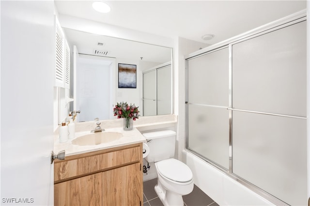 full bathroom featuring vanity, toilet, bath / shower combo with glass door, and tile patterned floors