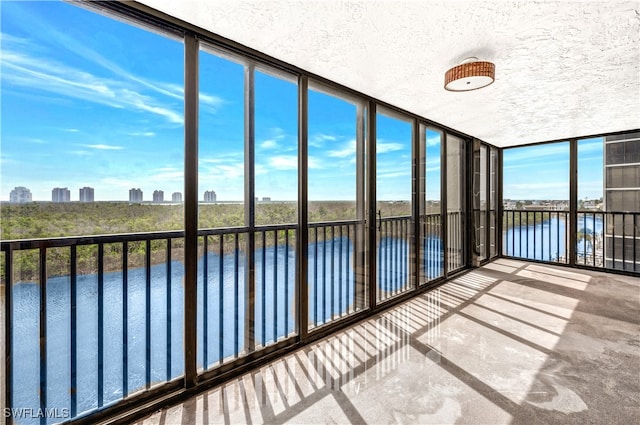 unfurnished sunroom featuring a water view