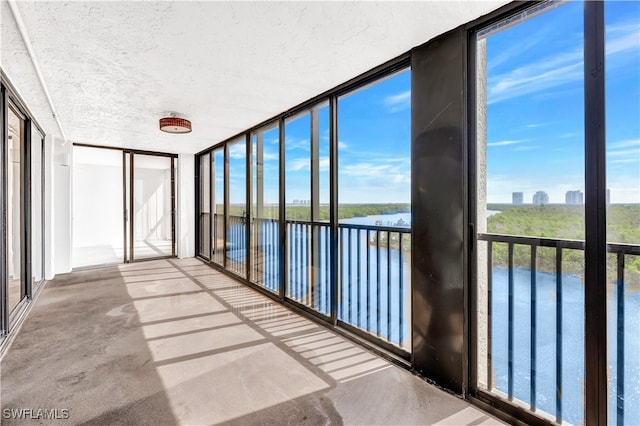 unfurnished sunroom featuring a healthy amount of sunlight and a water view