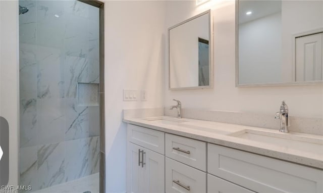 bathroom with vanity and a tile shower