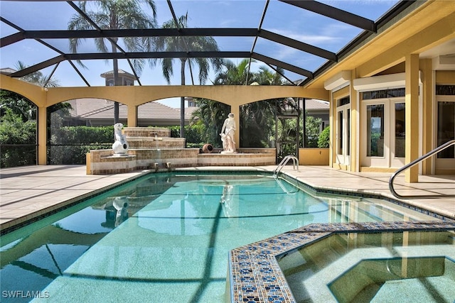 view of swimming pool featuring a patio, a lanai, and a pool with connected hot tub