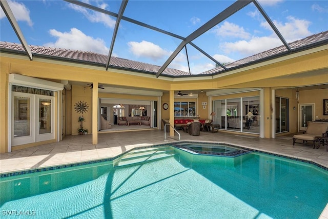 view of swimming pool featuring a pool with connected hot tub, ceiling fan, a lanai, outdoor lounge area, and a patio area