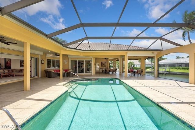 view of swimming pool featuring a patio area, glass enclosure, an outdoor hangout area, and a ceiling fan