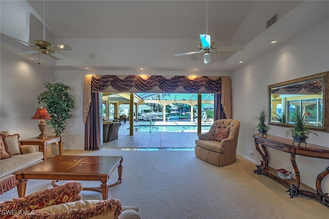 living room with visible vents, a ceiling fan, a tray ceiling, recessed lighting, and carpet flooring