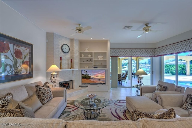 living area with light tile patterned floors, a fireplace, visible vents, and ceiling fan