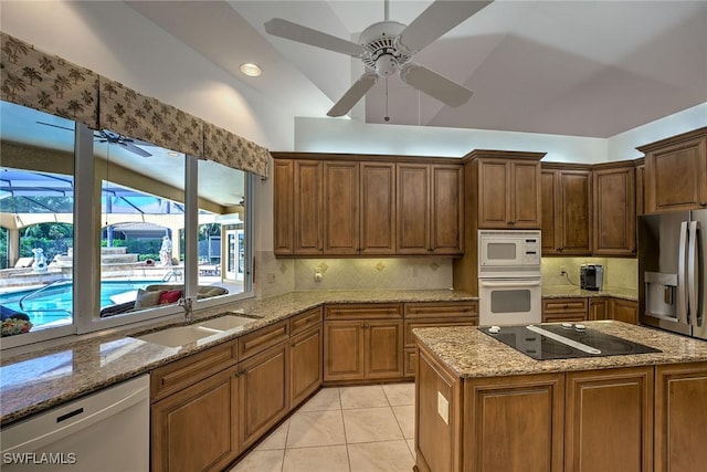 kitchen with light tile patterned floors, stainless steel appliances, tasteful backsplash, and a sink